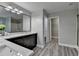 Bathroom features double vanity, quartz countertops, large mirror, gray walls and vinyl plank flooring at 969 Bob Hannah Cir, Lawrenceville, GA 30044