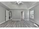 Spacious bedroom with tray ceilings, ceiling fan, vinyl plank flooring, and two windows at 969 Bob Hannah Cir, Lawrenceville, GA 30044