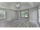 Spacious bedroom with tray ceilings, ceiling fan, vinyl plank flooring, two windows and glass paneled door at 969 Bob Hannah Cir, Lawrenceville, GA 30044
