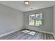 Bedroom with gray walls, a window, light fixture and wood-look flooring at 969 Bob Hannah Cir, Lawrenceville, GA 30044