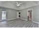 Spacious bedroom with tray ceilings, ceiling fan, vinyl plank flooring, and two windows at 969 Bob Hannah Cir, Lawrenceville, GA 30044