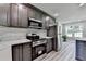 Modern kitchen features gray cabinets, stainless appliances, white countertops and gray vinyl plank flooring at 969 Bob Hannah Cir, Lawrenceville, GA 30044