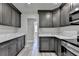 Modern kitchen features gray cabinets, stainless appliances, white countertops and gray vinyl plank flooring at 969 Bob Hannah Cir, Lawrenceville, GA 30044