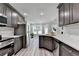 Modern kitchen with gray cabinets, stainless steel appliances and light gray wood flooring, open to the living room at 969 Bob Hannah Cir, Lawrenceville, GA 30044
