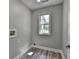 Bright laundry room with wood-look flooring and natural light from a window at 969 Bob Hannah Cir, Lawrenceville, GA 30044