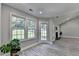 Bright sunroom with large windows, light gray wood floors and a backyard view at 969 Bob Hannah Cir, Lawrenceville, GA 30044