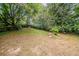 Spacious backyard featuring mature trees and partial fencing, offering a private outdoor space at 1060 Heatherwood Ct, Norcross, GA 30093