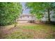 Backyard features a deck, house view, and mature trees providing shade and privacy at 1060 Heatherwood Ct, Norcross, GA 30093
