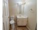 Neutral bathroom features a white vanity, standard mirror, and a toilet with a matching seat at 1060 Heatherwood Ct, Norcross, GA 30093
