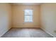 A bedroom with a neutral carpet, a large window, and plain walls at 1060 Heatherwood Ct, Norcross, GA 30093