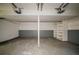 Functional garage features concrete flooring, painted walls, and built-in shelving for organized storage at 1060 Heatherwood Ct, Norcross, GA 30093