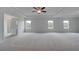 Primary bedroom with tray ceiling, carpet floors, and many windows at 111 Felicity Pike, Locust Grove, GA 30248