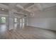 Open concept living room with hardwood floors, coffered ceiling, chandelier and wainscotting at 111 Felicity Pike, Locust Grove, GA 30248