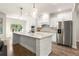 Modern kitchen with an island, stainless steel appliances, granite countertops, and herringbone tile backsplash at 2124 Bullock Bluff Dr, Loganville, GA 30052