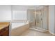 Primary bathroom featuring tile flooring, granite countertops, a glass shower, and a soaking tub at 307 Heritage Overlook, Woodstock, GA 30188