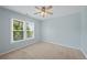 Bright bedroom features a ceiling fan, neutral carpet, and a large window at 307 Heritage Overlook, Woodstock, GA 30188
