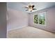 Sunlit bedroom featuring a ceiling fan and a double window overlooking greenery at 307 Heritage Overlook, Woodstock, GA 30188