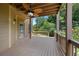 Spacious covered deck featuring a ceiling fan, wood flooring, and serene views of the surrounding greenery at 307 Heritage Overlook, Woodstock, GA 30188