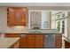 Kitchen with granite counters, stainless appliances, and a view into the Gathering room with a stone fireplace at 307 Heritage Overlook, Woodstock, GA 30188