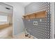 Well-lit laundry room with stylish wallpaper and shelving; adjacent to the bathroom at 307 Heritage Overlook, Woodstock, GA 30188