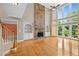 Bright living room featuring hardwood floors, a stone fireplace, and large windows at 307 Heritage Overlook, Woodstock, GA 30188