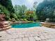 Sparkling pool with stone accents, a basketball hoop, and lush landscaping for a serene outdoor escape at 307 Heritage Overlook, Woodstock, GA 30188