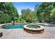 Inviting backyard pool and spa surrounded by lush landscaping, perfect for outdoor relaxation at 307 Heritage Overlook, Woodstock, GA 30188