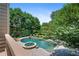 Aerial view of the in-ground pool and jacuzzi surrounded by mature trees and lush landscaping at 307 Heritage Overlook, Woodstock, GA 30188