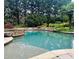 Backyard swimming pool featuring rock accents, lush landscaping, and pristine clear water at 307 Heritage Overlook, Woodstock, GA 30188
