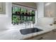 Bright kitchen featuring a garden window with marble countertops and stainless steel faucet at 1020 Matheson Way, Johns Creek, GA 30022