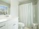 Bright bathroom with a single sink vanity, white cabinets and a shower-tub with white curtain at 1878 Weston Ln, Tucker, GA 30084