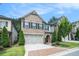 Brick front home with dark shutters, two-car garage, green lawn and mature landscaping at 1878 Weston Ln, Tucker, GA 30084