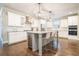Modern kitchen features white cabinets, stainless steel appliances, and an island with seating at 1878 Weston Ln, Tucker, GA 30084