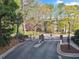 Secure gated entrance to the neighborhood with lush trees and landscaping at 4333 Dunwoody Park, Atlanta, GA 30338