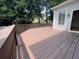 Wide shot of the wood deck with railing with trees visible in background, great for outdoor living at 5014 Dovecote Trl, Suwanee, GA 30024