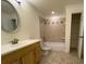 Well-lit bathroom featuring a vanity, toilet, and tiled shower-tub combo, plus a closet for ample storage at 5014 Dovecote Trl, Suwanee, GA 30024