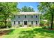 Charming two-story home with a lush green lawn and mature trees at 5018 Old Ivy Rd, Peachtree Corners, GA 30096