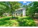 Home's exterior with a well-manicured lawn and mature trees at 5018 Old Ivy Rd, Peachtree Corners, GA 30096