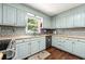 Well-lit kitchen with light blue cabinets, stainless steel appliances, and hardwood floors at 5018 Old Ivy Rd, Peachtree Corners, GA 30096