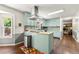 Updated kitchen featuring light blue cabinets, an island, hardwood floors, and backyard views at 5018 Old Ivy Rd, Peachtree Corners, GA 30096