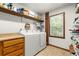 Bright laundry room features a side by side washer and dryer and a window at 5018 Old Ivy Rd, Peachtree Corners, GA 30096