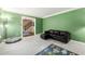 Cozy living room with gray carpet, a black sofa, and bright green walls at 5018 Old Ivy Rd, Peachtree Corners, GA 30096