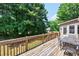 View of the wooden back deck with outdoor seating and a view of the trees at 672 Red Sunset Cir, Powder Springs, GA 30127