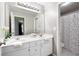 Bright bathroom featuring double sinks, white cabinets and a shower with a polka dot curtain at 672 Red Sunset Cir, Powder Springs, GA 30127
