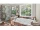Beautiful bathroom with a tiled shower and large soaking tub next to a bright window at 672 Red Sunset Cir, Powder Springs, GA 30127