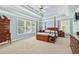 Large bedroom with tray ceilings, wood furniture, carpet, and natural light at 672 Red Sunset Cir, Powder Springs, GA 30127