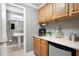Butler's pantry with wooden cabinets, beverage cooler, and a view into the bathroom with pedestal sink at 672 Red Sunset Cir, Powder Springs, GA 30127
