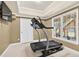 Bright exercise room with treadmill, neutral carpet, recessed ceiling, and a large window overlooking the backyard at 672 Red Sunset Cir, Powder Springs, GA 30127
