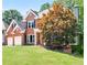 Charming two-story red brick home with a well-manicured lawn, a two-car garage, and mature trees at 672 Red Sunset Cir, Powder Springs, GA 30127