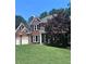 Traditional brick home with a well-maintained lawn and mature trees at 672 Red Sunset Cir, Powder Springs, GA 30127